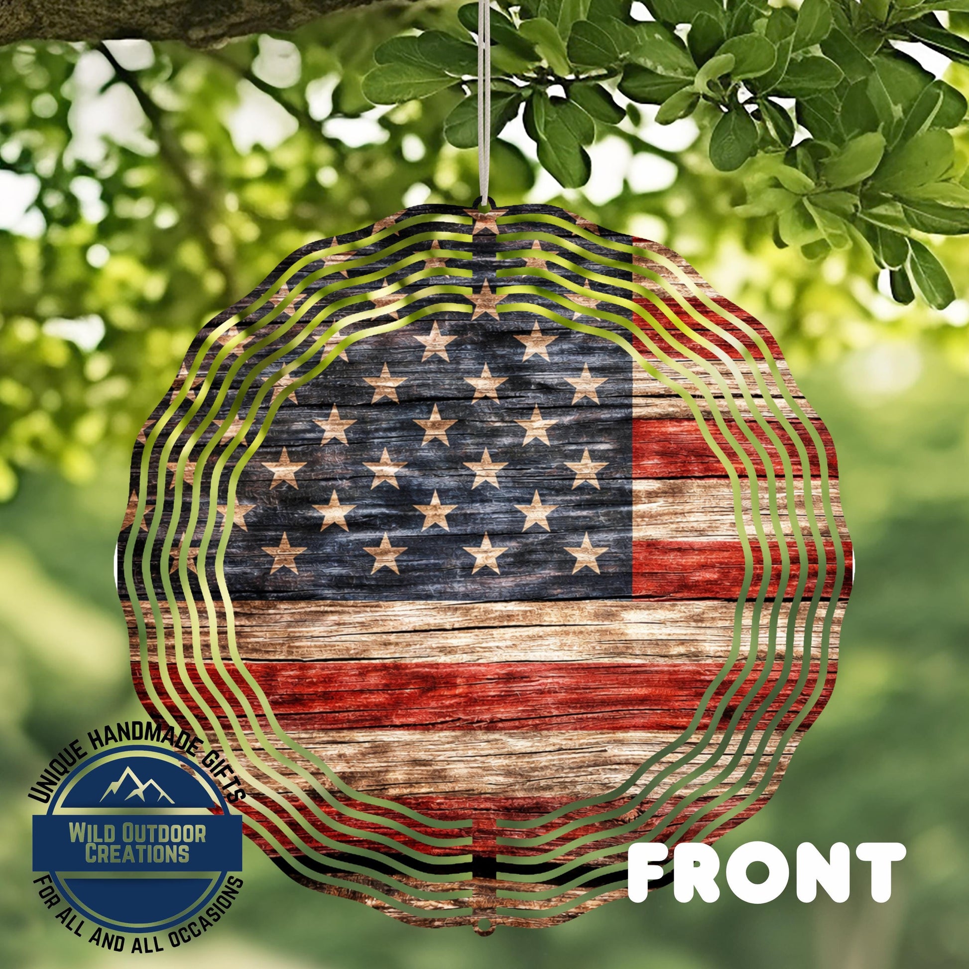 a large American flag-themed wind chime hanging from a tree branch.