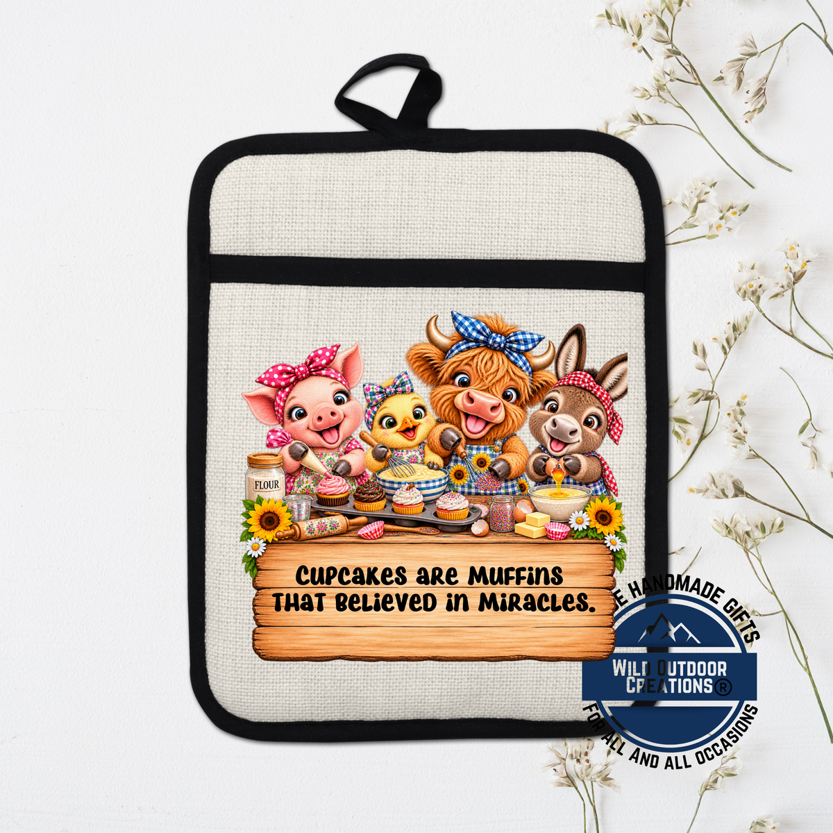 A hand-made pot holder with a cartoon illustration of four cute animals, including a pig, cow, duck, and chicken, along with the text "Cupcakes are Muffins that believed in Miracles."