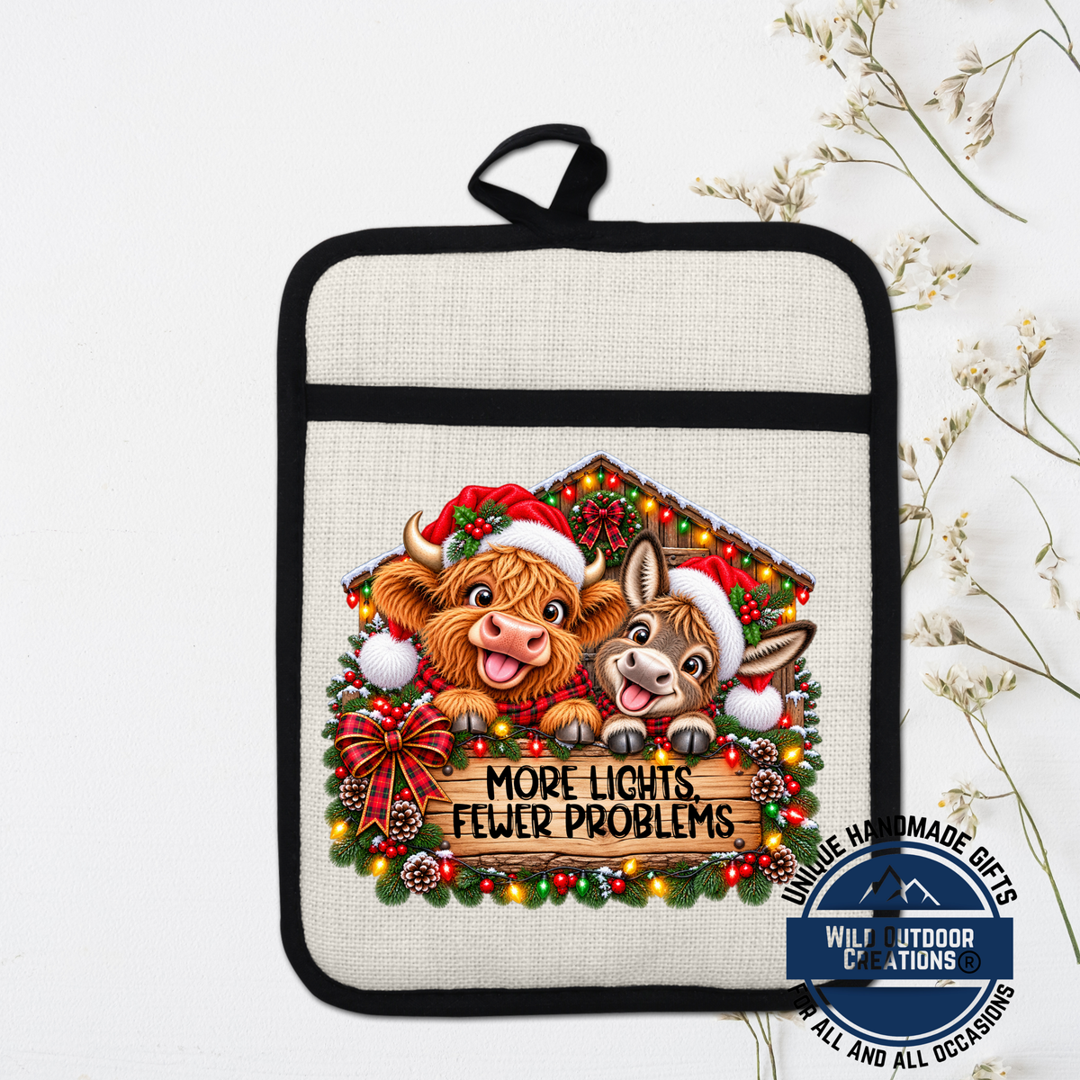A kitchen pot holder with a Christmas-themed design featuring two cartoon animals, a cow and a donkey, wearing Santa hats and surrounded by Christmas decorations.