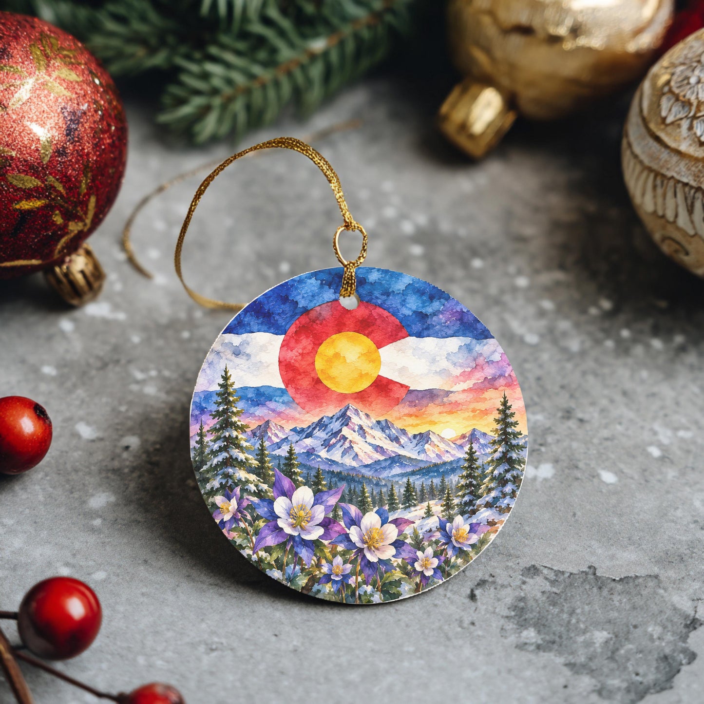 A round ornament featuring a colorful mountain landscape with a red sun, surrounded by flowers and pine trees.