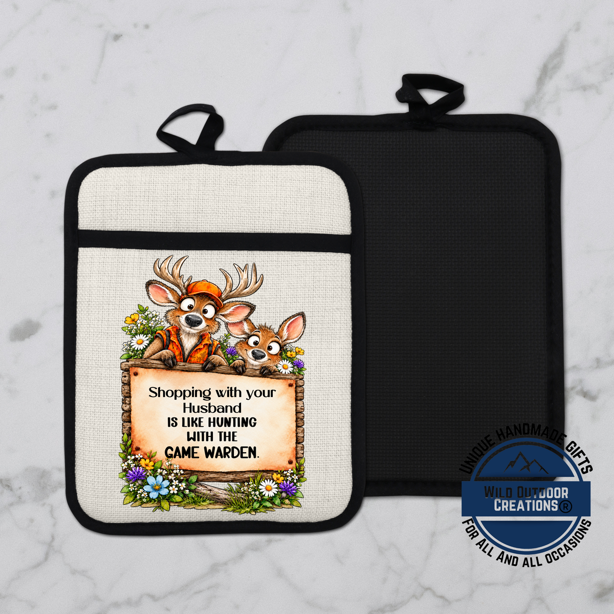 A white and black pot holder with a cartoon image of two deer and a sign that reads "Shopping with your husband is like hunting with the camewolf".