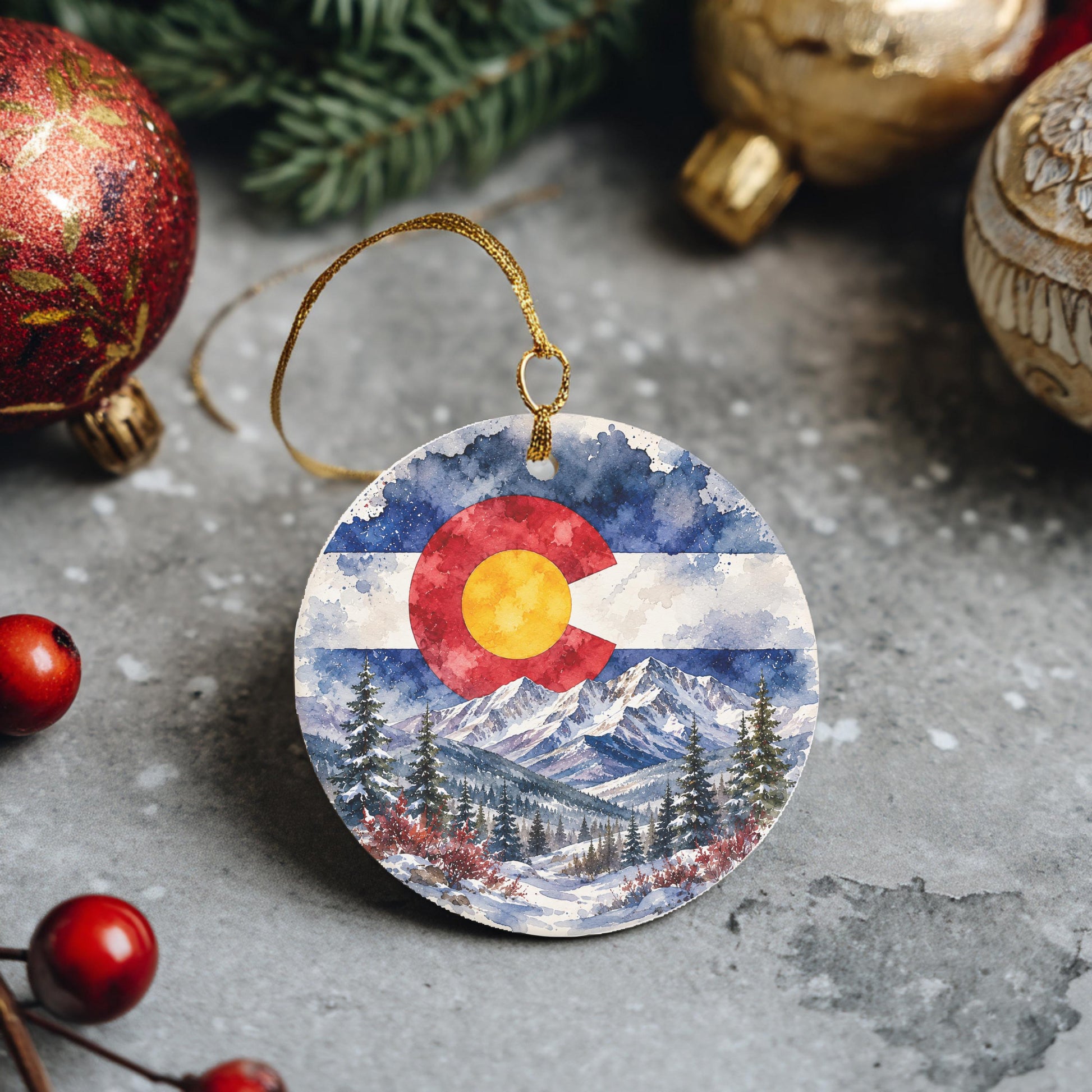 A round ornament featuring a watercolor painting of the Colorado state landscape, with a red, white, and blue color scheme.
