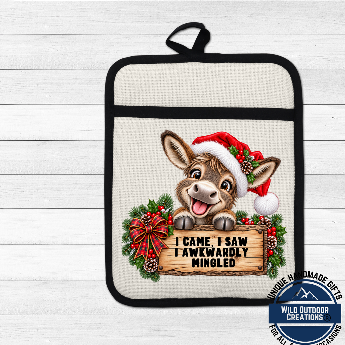 A pot holder with a cartoon donkey wearing a Santa hat and holding a sign that says "I came, I saw I awkwardly mingled".