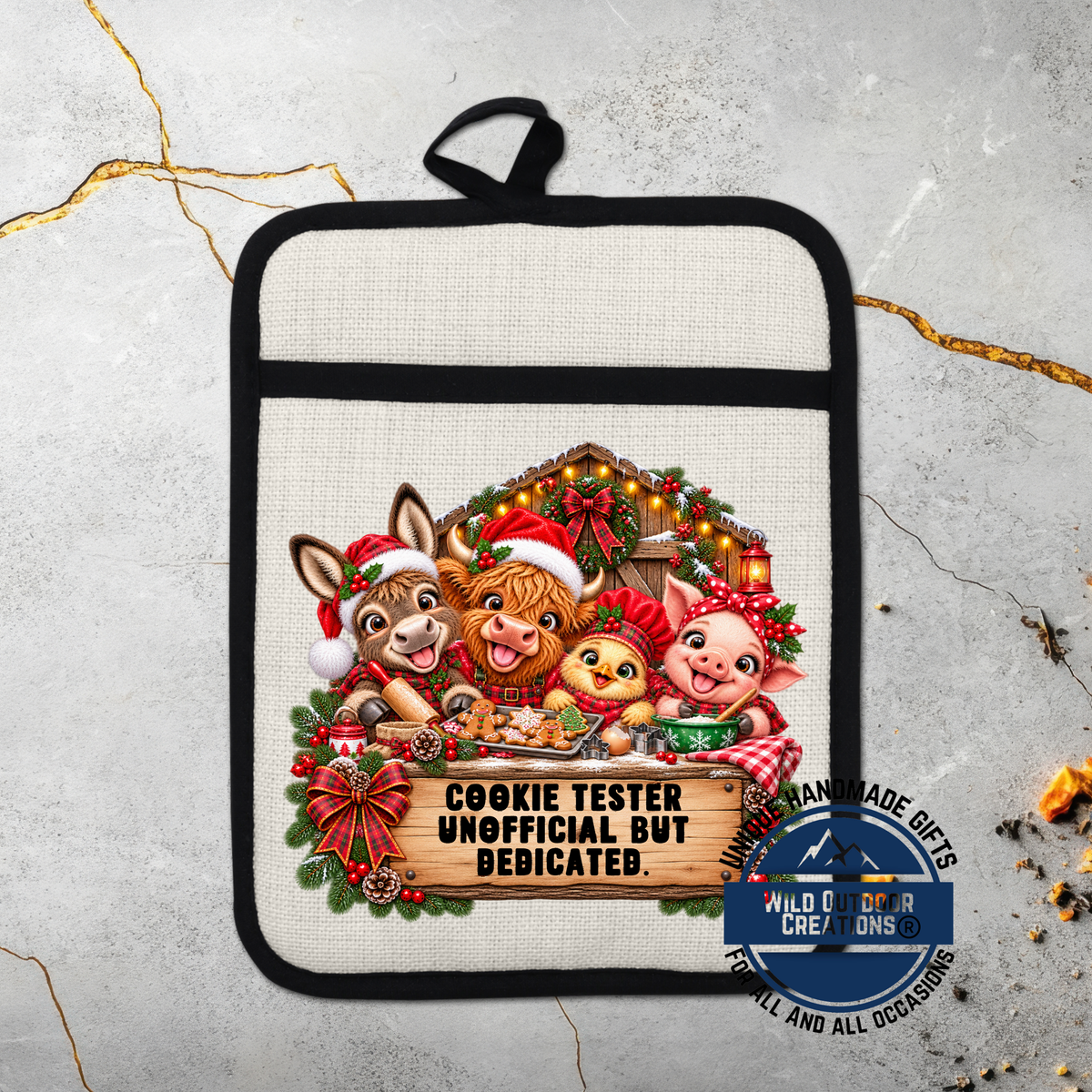A beige oven mitt with a black handle, featuring a festive Christmas-themed design with cartoon animals and a sign that reads "COOKIE TESTER UNOFFICIAL BUT BEDICATED".