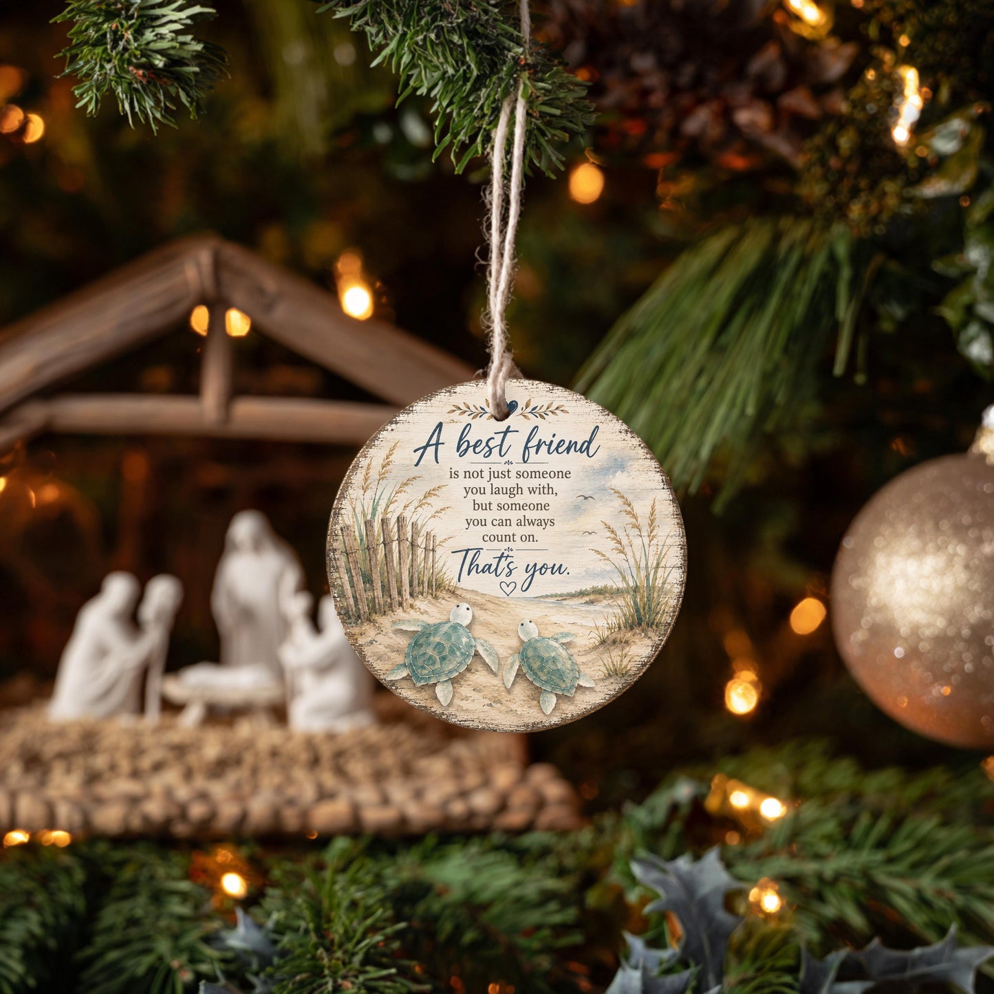 A round ornament hanging from a Christmas tree, featuring a message about being a best friend.