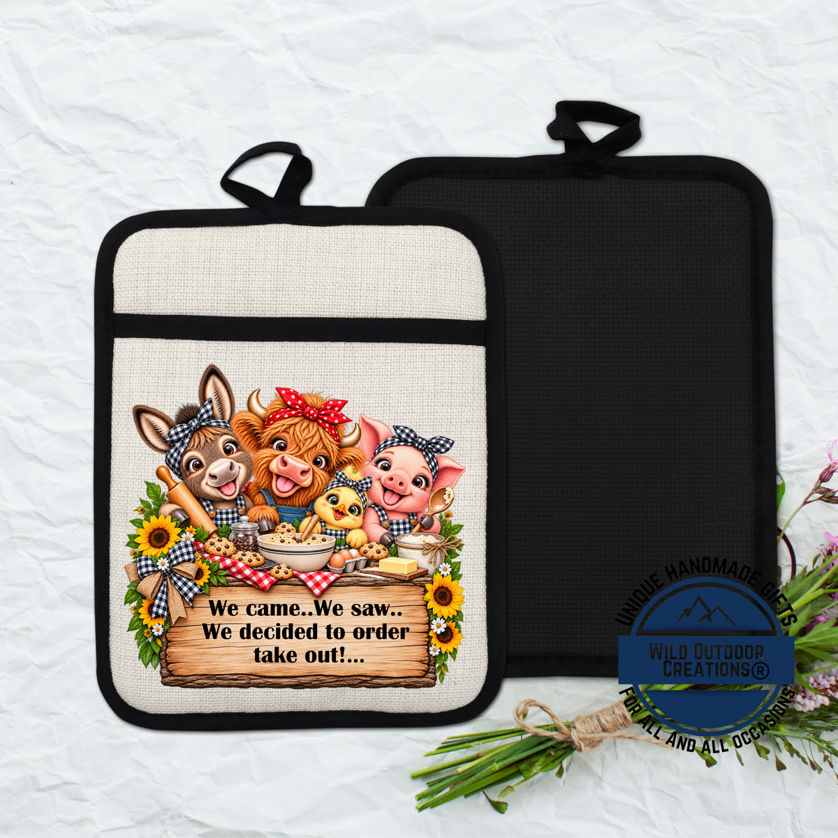 A kitchen pot holder with a cartoon illustration of farm animals, including a cow, pig, and chicken, along with a sign that says "We came. We saw... We decided to order take out..." The pot holder is placed on a white surface, and there is a bouquet of flowers nearby.