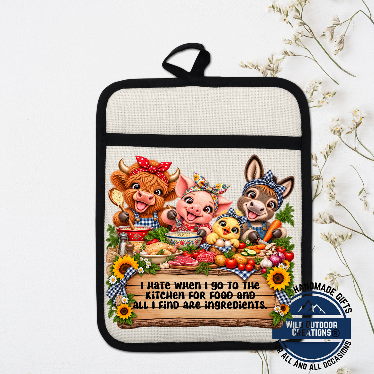 A hand-made oven mitt with a cartoon illustration of three animals, including a cow, pig, and rabbit, sitting around a table with various food items. The mitt has a humorous message printed on it.