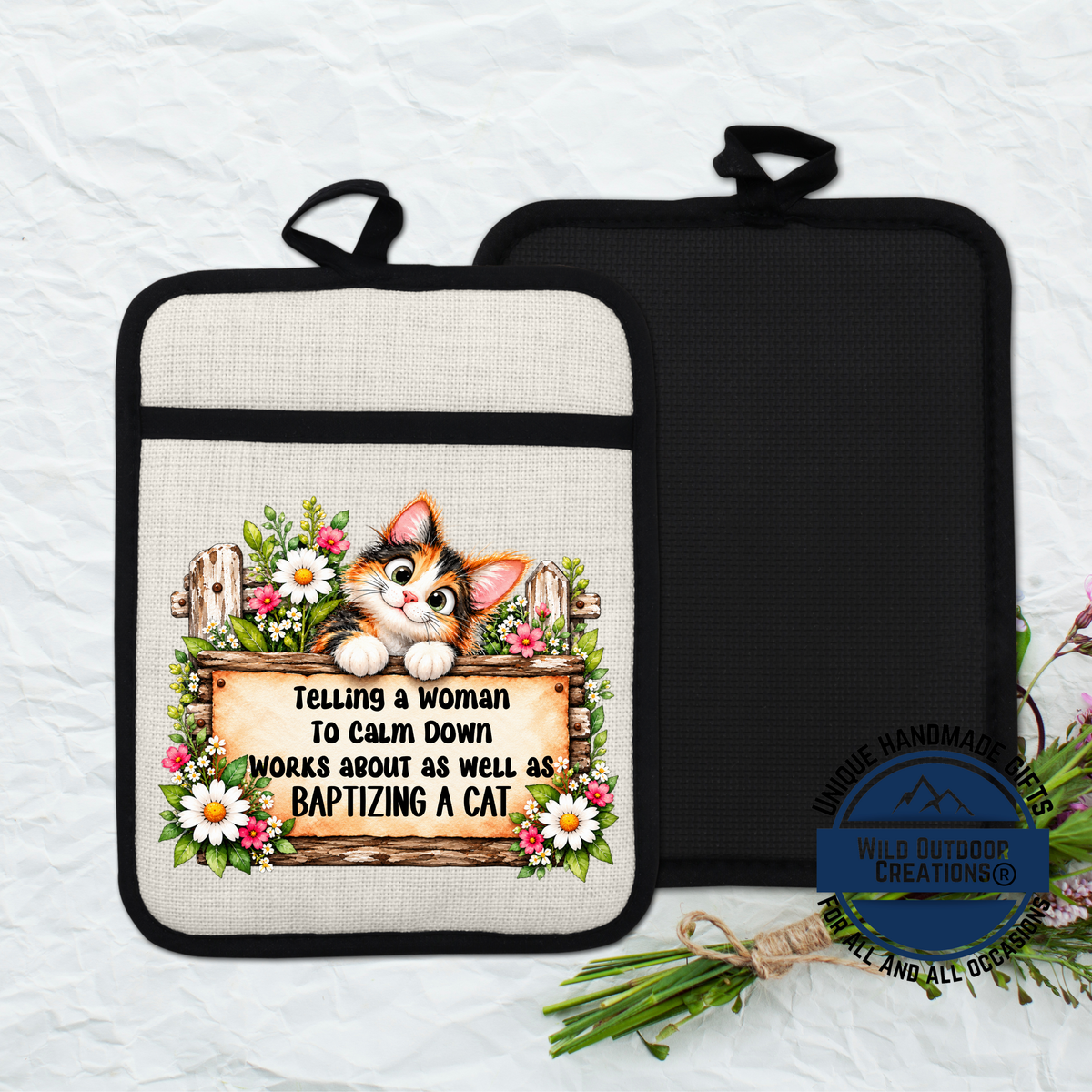 A kitchen pot holder with a printed design featuring a cat and a sign that says "Telling a woman to calm down works about as well as baptizing a cat".