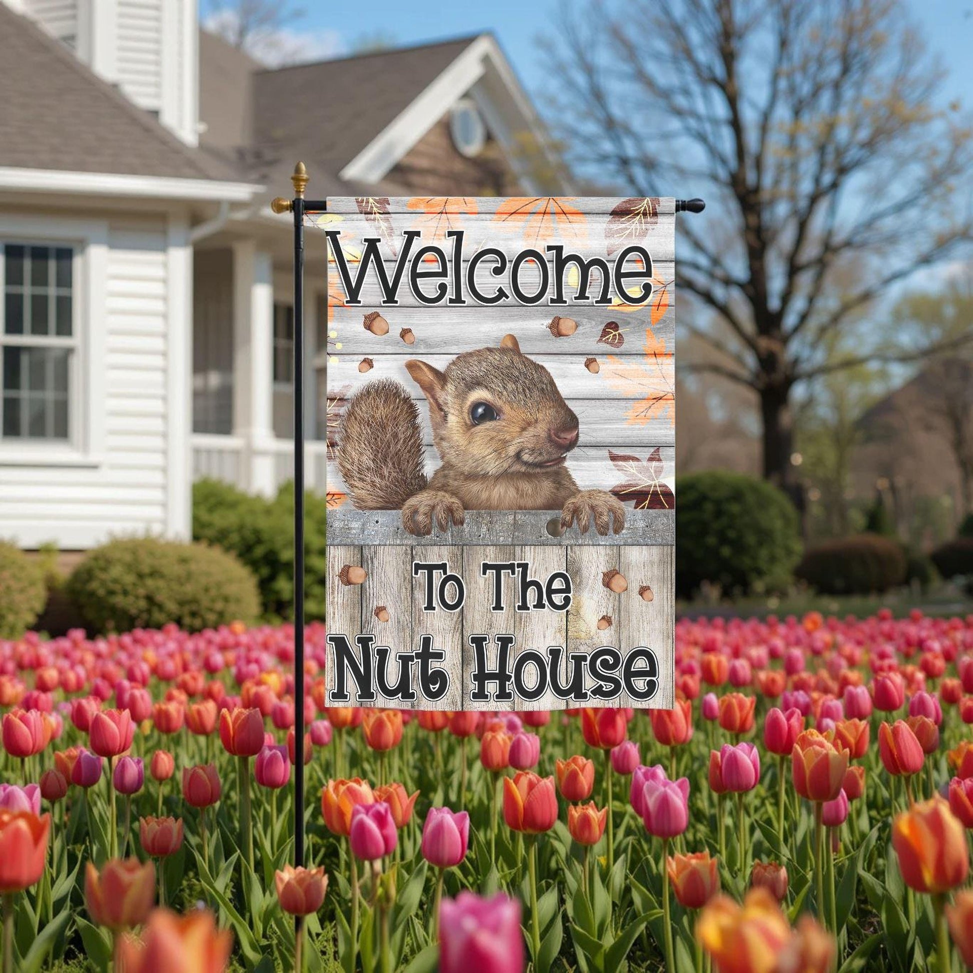 A wooden sign with a squirrel on it, placed in a field of colorful tulips.