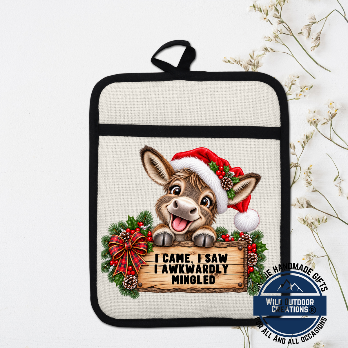 A pot holder with a cartoon donkey wearing a Santa hat and holding a sign that says "I came, I saw, I Awkwardly Minced".
