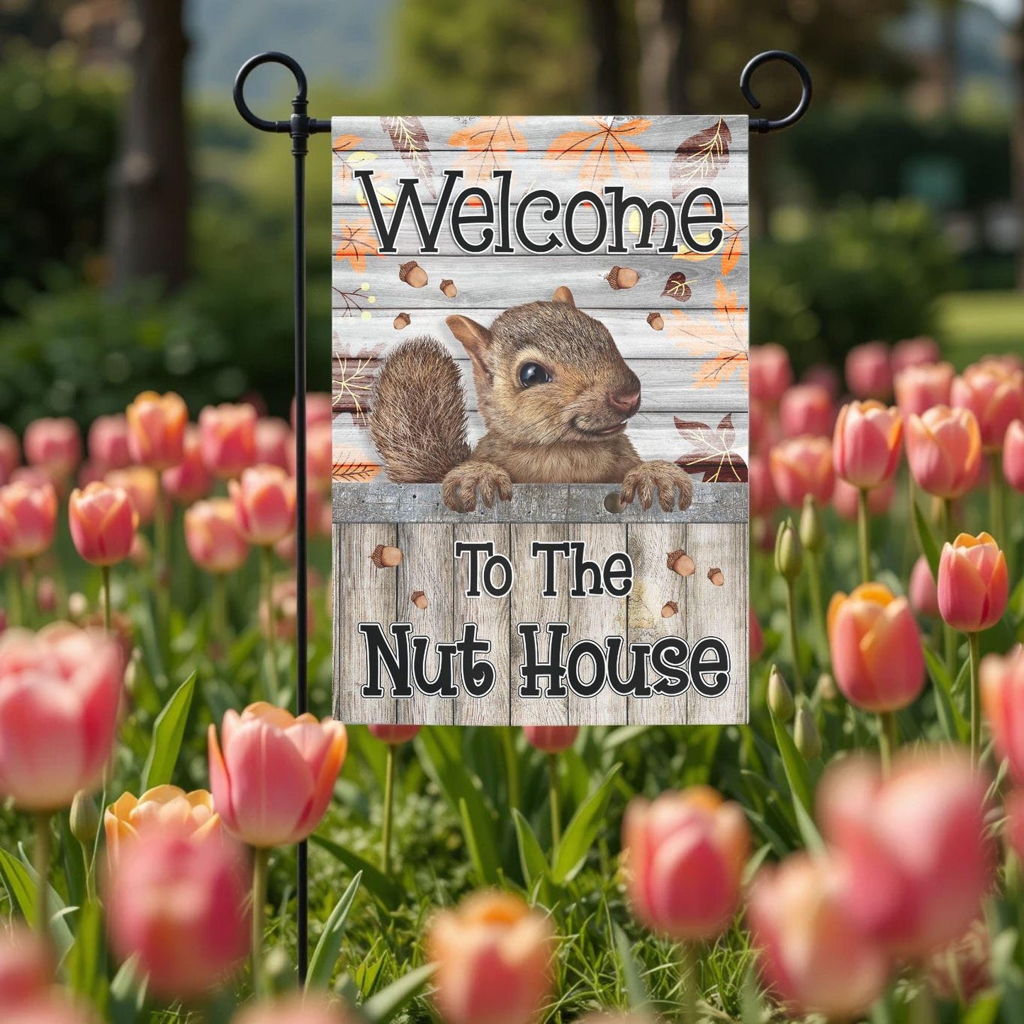 A garden flag with a squirrel on it, displaying the text "Welcome to the Nut House".