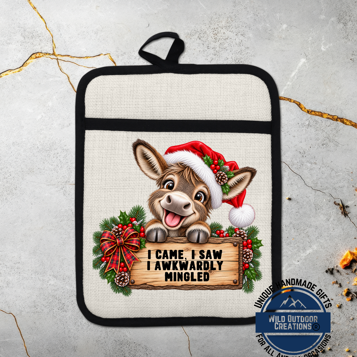 A kitchen pot holder with a cartoon donkey wearing a Santa hat and holding a sign that says "I came, I saw IAWWARDLY MINDLED".