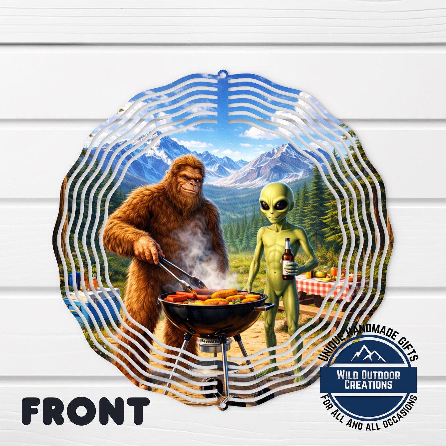 A large, furry alien creature is shown cooking food on a grill, while a human-like creature, possibly a gorilla or a Sasquatch, stands nearby. The scene appears to be set in a mountainous, forested area.