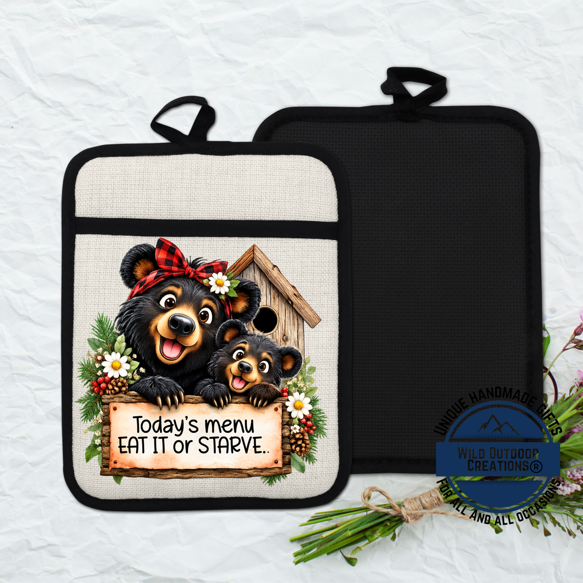 A kitchen pot holder with a printed design featuring two bears, one larger and one smaller, sitting in a birdhouse and holding a sign that says "Today's menu eat it or starve".