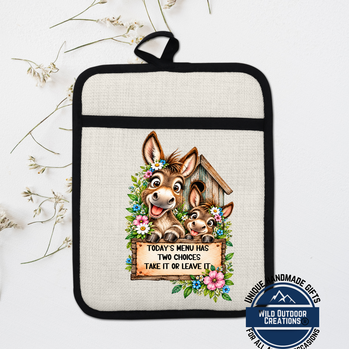 A hand-made pot holder with a cartoon donkey and a sign that says "Today's Menu Has Two Choices Take It or Leave It".