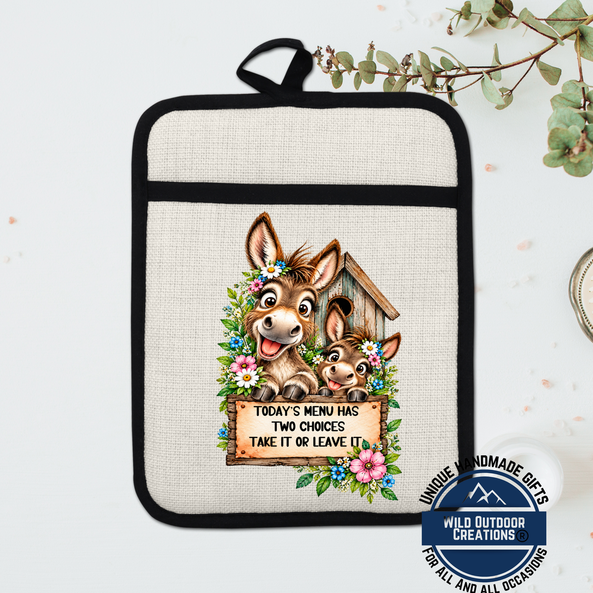 A beige pot holder with a cartoon donkey and a sign that says "Today's menu has two choices take it or leave it" printed on it.