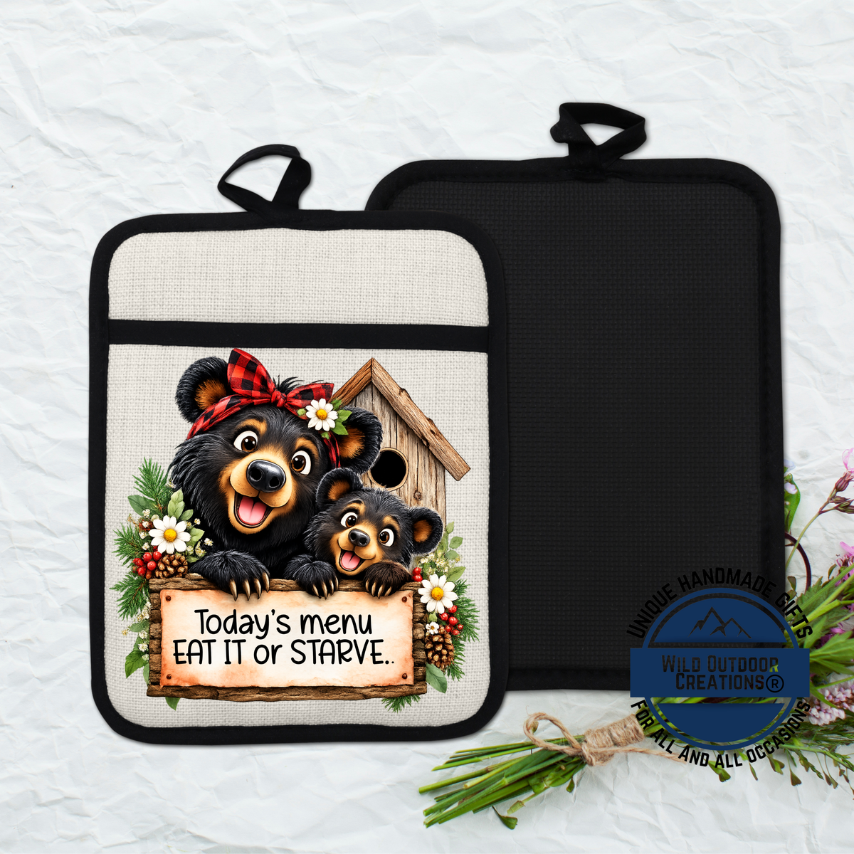 A kitchen pot holder with a cartoon image of two bears, one larger and one smaller, sitting in a birdhouse and holding a sign that says "Today's menu eat it or starve".