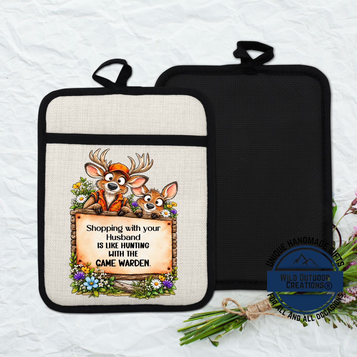 A beige oven mitt with a cartoon image of two deer and a sign that reads "Shopping with your husband is like hunting with the camewolf".