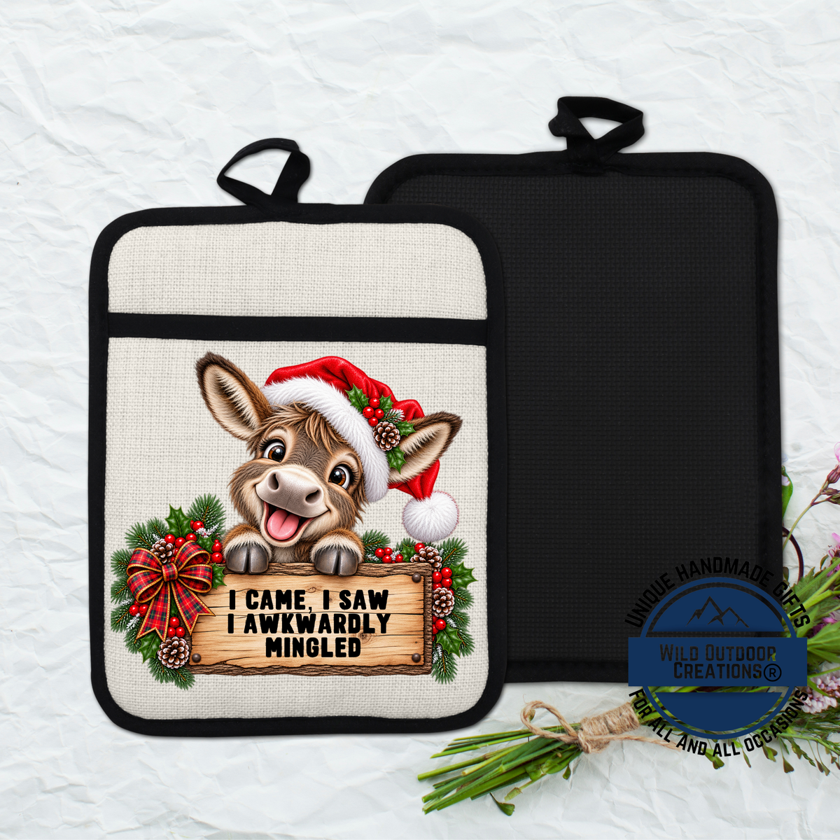 A pot holder with a cartoon donkey wearing a Santa hat and holding a sign that says "I Came, I Saw, I Wrote Minged".