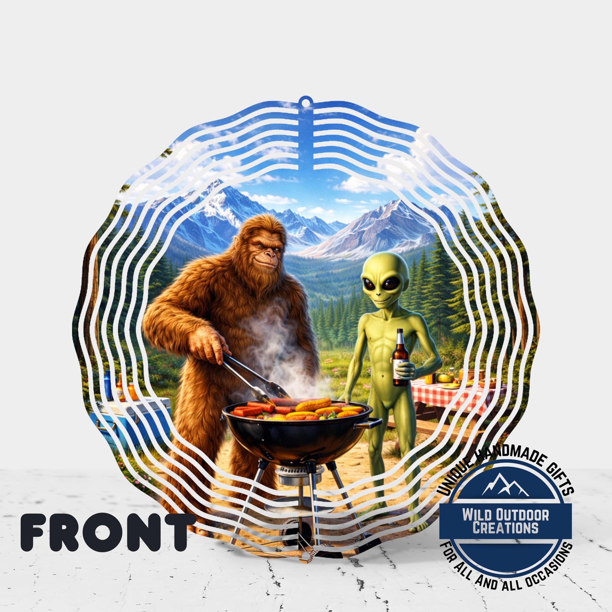 The image is a collage featuring a large brown alien and a large brown gorilla grilling food outdoors. The alien is holding a bottle of beer, and the gorilla is holding a spatula. The background depicts a mountainous landscape with a blue sky and clouds.