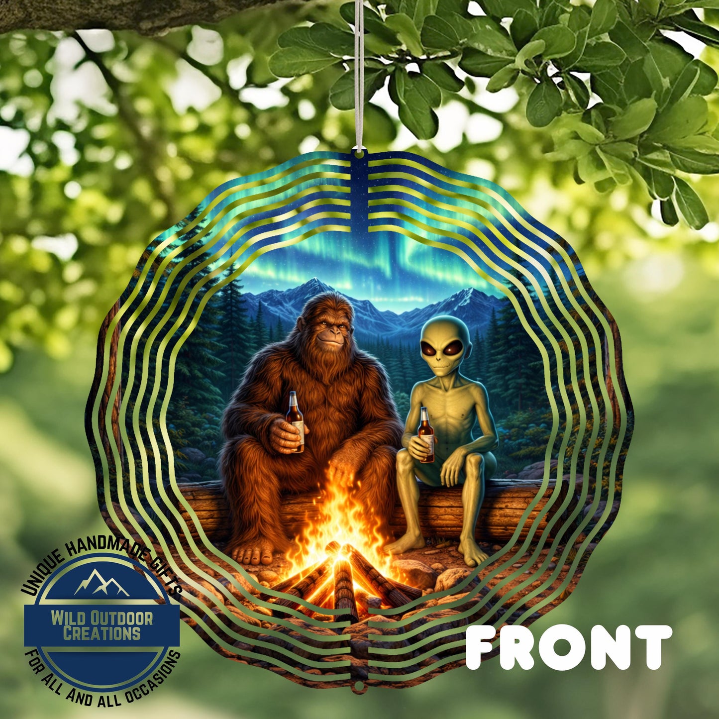 A large, circular wind chime with a depiction of a giant brown furry creature and a smaller alien-like creature sitting by a campfire. The background features a forest and a stunning night sky with the northern lights.