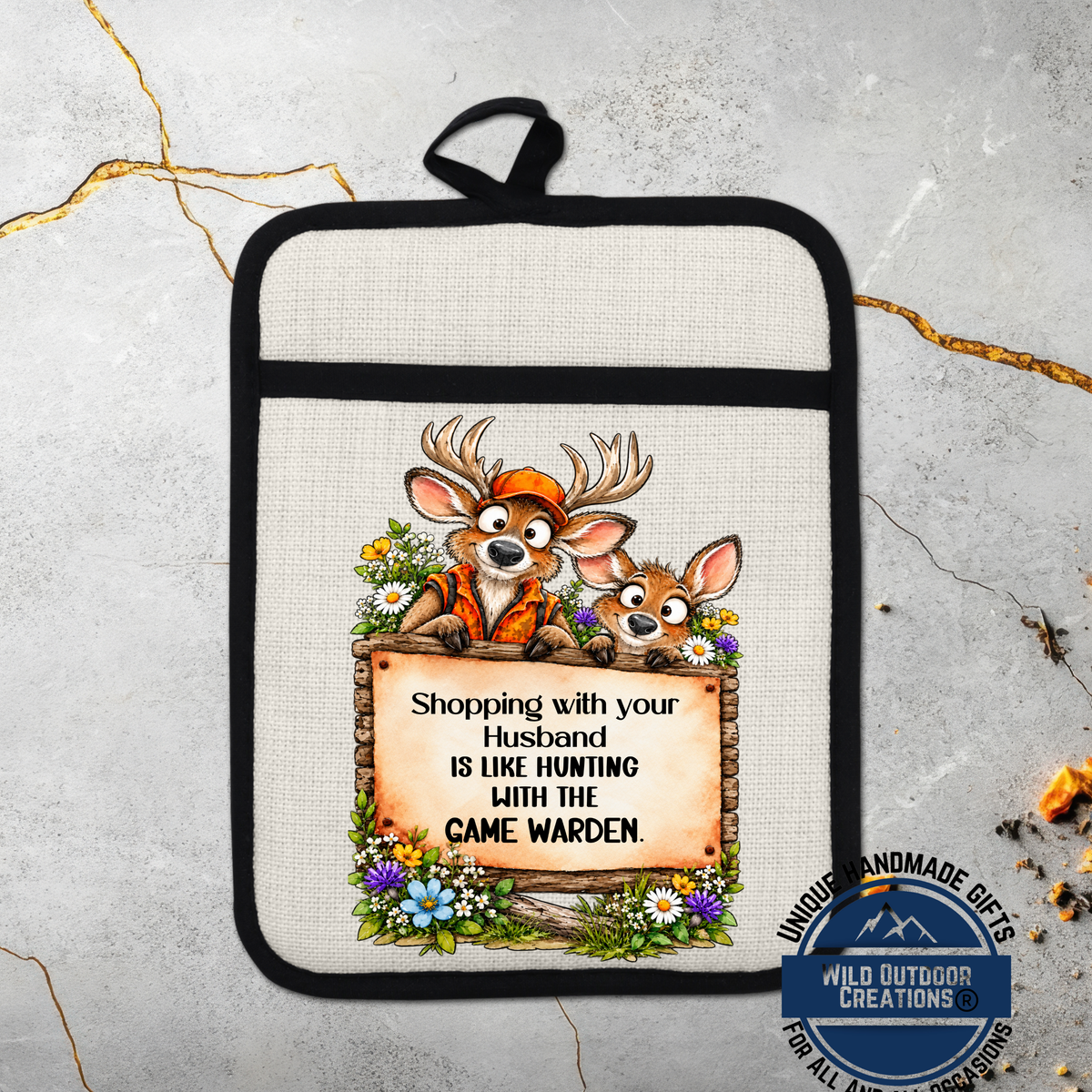 A kitchen pot holder with a cartoon image of two deer wearing hunting gear and a sign that says "Shopping with your husband is like hunting with the game warden".