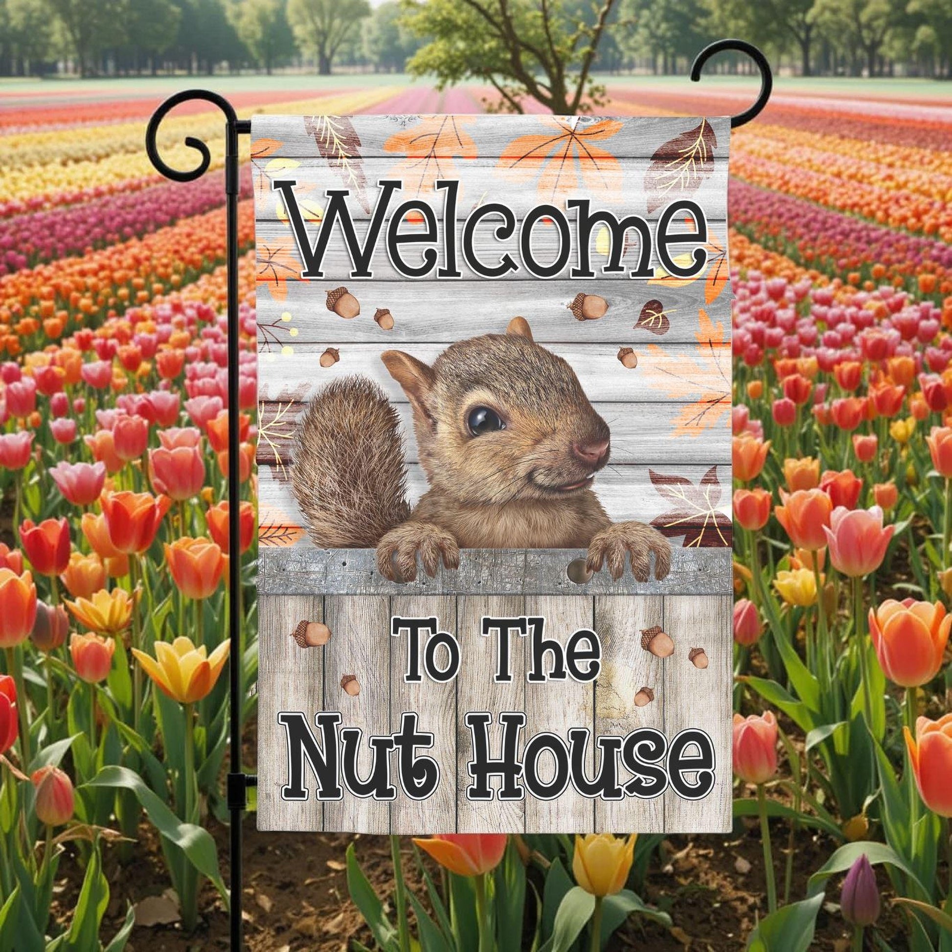 A garden flag with a squirrel on it, displaying the text "Welcome to the Nut House".