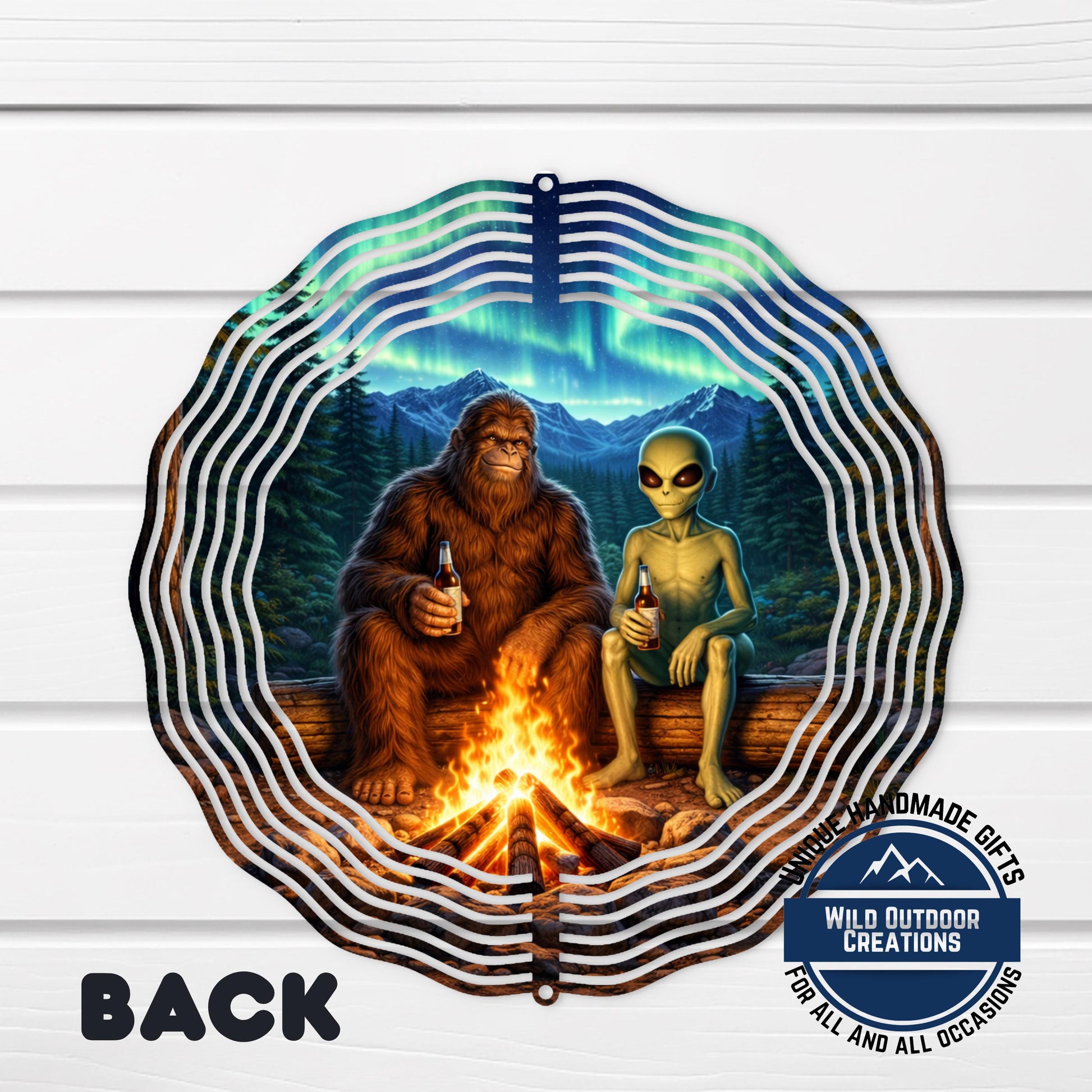 A large metal wind chime with a design featuring a giant brown furry creature and a smaller alien-like creature sitting by a campfire.