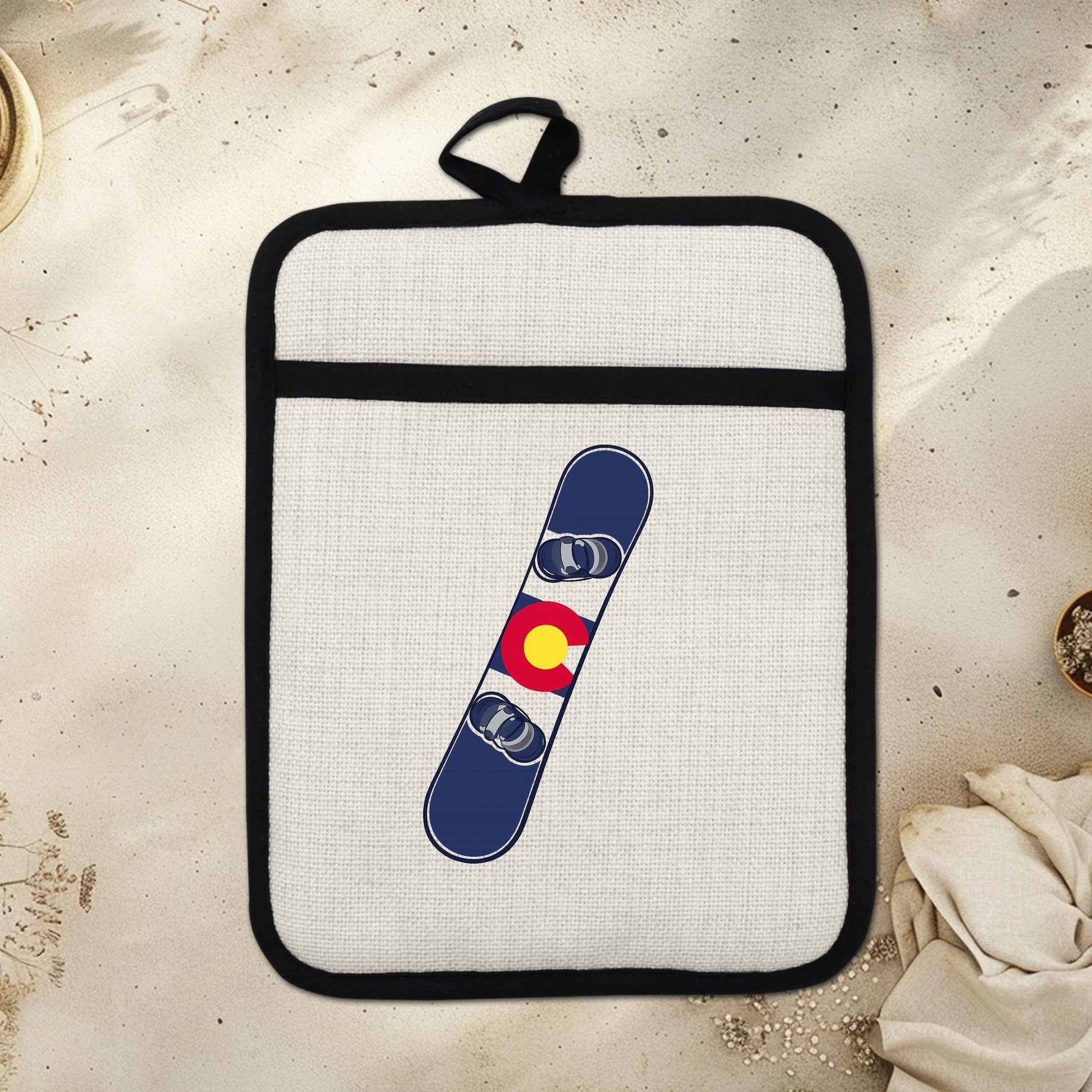 Snowboard Pot Holder - Colorado Flag Design | Linen Fabric & Silicone Backing Pad Trivet - displayed in garden