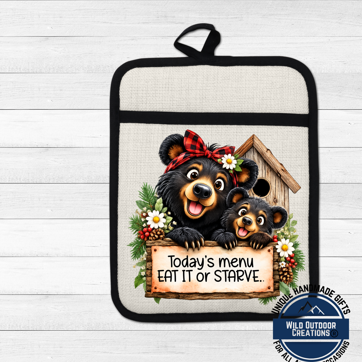 A kitchen pot holder with a cartoon image of two bears, one larger and one smaller, peeking out from behind a sign that says "Today's menu eat it or Starve."