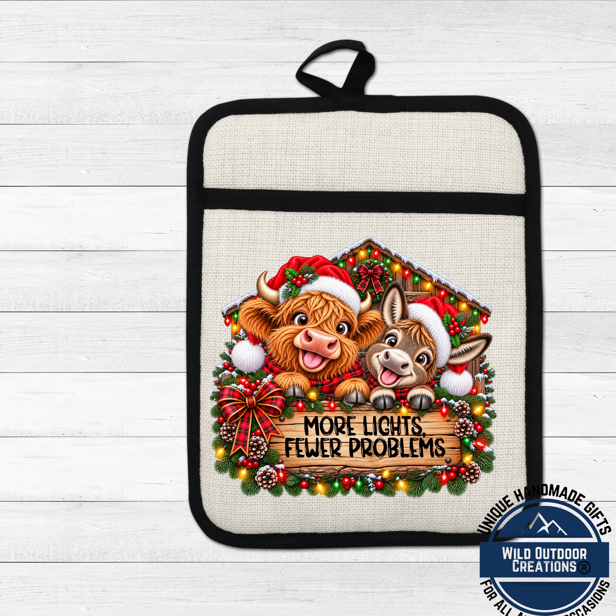 A kitchen pot holder with a Christmas-themed design featuring two cartoon animals, a cow and a donkey, wearing Santa hats and surrounded by Christmas lights and decorations.